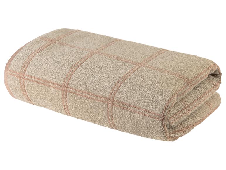 Serviette de bain beige à carreaux rose pâle.