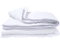 Couette blanche avec passepoil bleu, pliée en pile.
