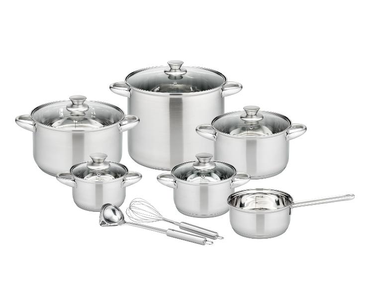 Un ensemble de quatre casseroles en acier inoxydable avec couvercles en verre, une louche et un fouet.