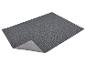 Tapis rectangulaire gris foncé avec un coin replié, montrant le dessous