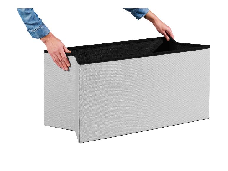 Personne assemblant une boîte de rangement pliable grise avec un intérieur noir.