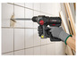 Une personne utilise une perceuse à percussion Parkside pour percer un mur en carrelage.