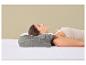 Femme dormant sur le dos sur un lit avec un oreiller ergonomique gris