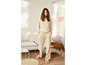 Une femme porte un survêtement beige avec un sweat-shirt et un pantalon.