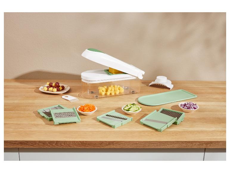 Ensemble de robot culinaire avec accessoires et légumes hachés.