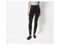 Pantalon noir ajusté avec une ceinture élastique et des chaussures habillées en daim marron.