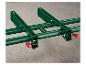 Système de rouleaux vert foncé pour table de scie, avec leviers rouges.