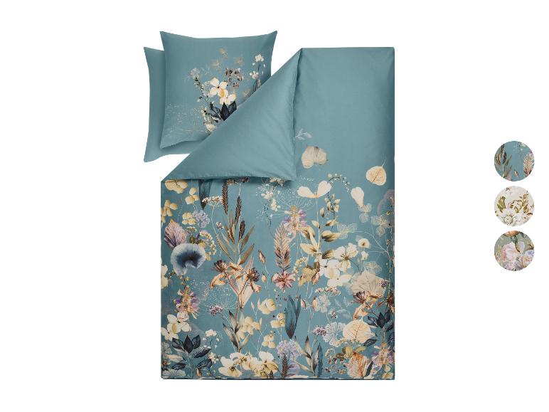 Parure de lit à motif floral dans les tons bleus et beiges, avec des motifs supplémentaires.