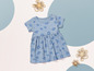 Une robe de bébé avec un imprimé floral bleu sur un fond blanc.
