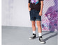 Un mannequin porte un t-shirt noir avec un imprimé graphique, un short en jean bleu et des baskets Converse noires.