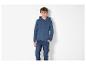 Un garçon porte un sweat à capuche bleu et un jean bleu.
