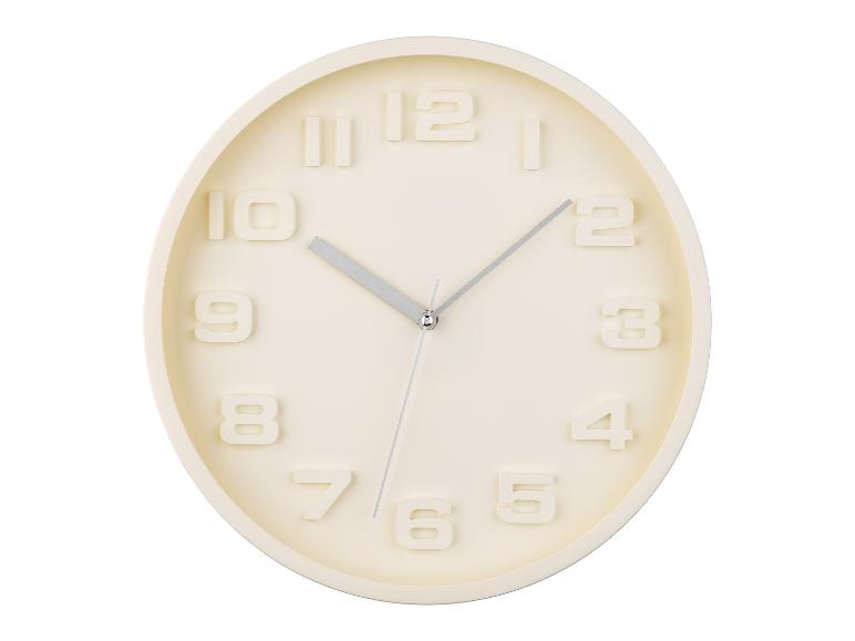 Horloge murale beige, design minimaliste, chiffres en relief.
