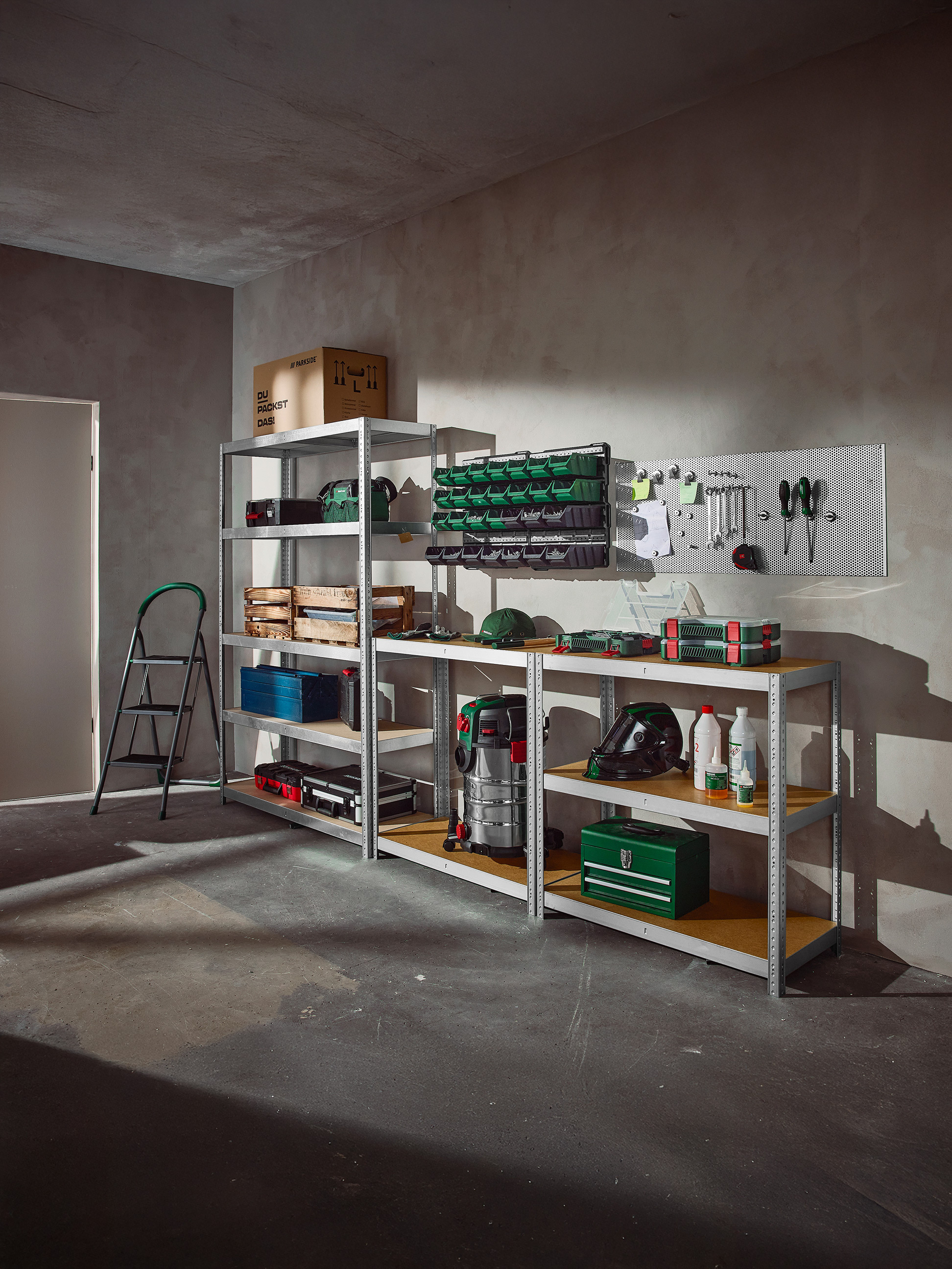 Garage organisé avec des étagères remplies d'outils, de boîtes de rangement et d'équipement d'atelier.