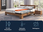 Un lit en bois avec un matelas à différents niveaux de fermeté.