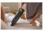 Personne nettoyant un canapé clair avec un aspirateur à main SilverCrest noir