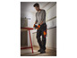 Un homme en tenue de travail utilise un outil Parkside pour le travail du bois.