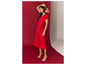Une femme en robe rouge à fleurs et talons beiges.
