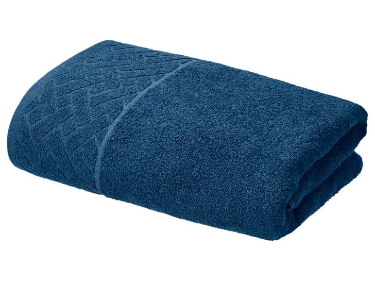 Serviette en coton bleu marine pliée avec motif décoratif.