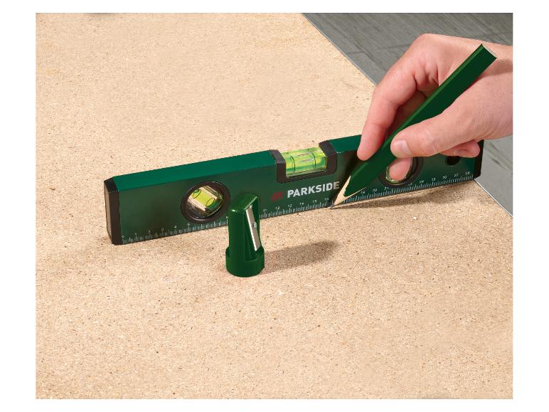 Niveau à bulle PARKSIDE et crayon utilisés pour marquer sur une surface en bois.