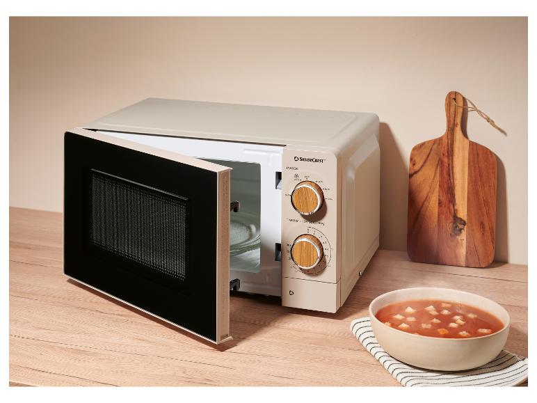 Micro-ondes beige avec porte ouverte, à droite un bol de soupe tomate avec croûtons.