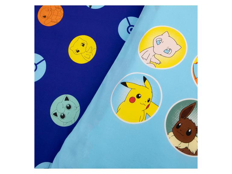 Tissu de lit bleu avec des imprimés de personnages de dessins animés en cercles.