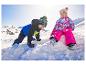 Deux jeunes enfants en vestes de ski colorées LUPILU® s'amusent dans la neige