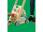 Bébé joue avec un trotteur en bois avec tableau d'activités, à côté d'un adulte.
