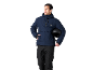 Homme en veste de ski bleu foncé et pantalon noir, tenant un casque noir.