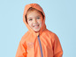 Un enfant portant un imperméable orange à capuche.