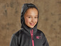 Une fille porte un sweat-shirt noir à capuche avec une fermeture éclair rose de la marque Adventure is out there.