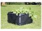 Composteur noir avec des plants de concombre dans un jardin vert.