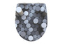 Un abattant de toilette avec un motif abstrait de cercles gris.