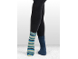 Jambes en leggings foncés, un pied dans une chaussette rayée, l'autre dans une chaussette bleue unie.