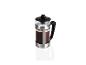Une cafetière à piston en verre et acier inoxydable avec du café.
