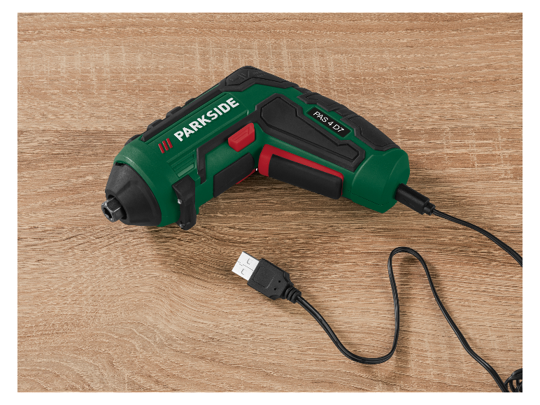 Un tournevis sans fil Parkside PAS 4 D7 avec câble USB sur une surface en bois.