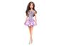 Poupée Barbie aux cheveux bruns, vêtue d'une robe violette scintillante et de sandales argentées.