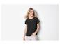 Femme en t-shirt noire avec détails ajourés et pantalon beige.