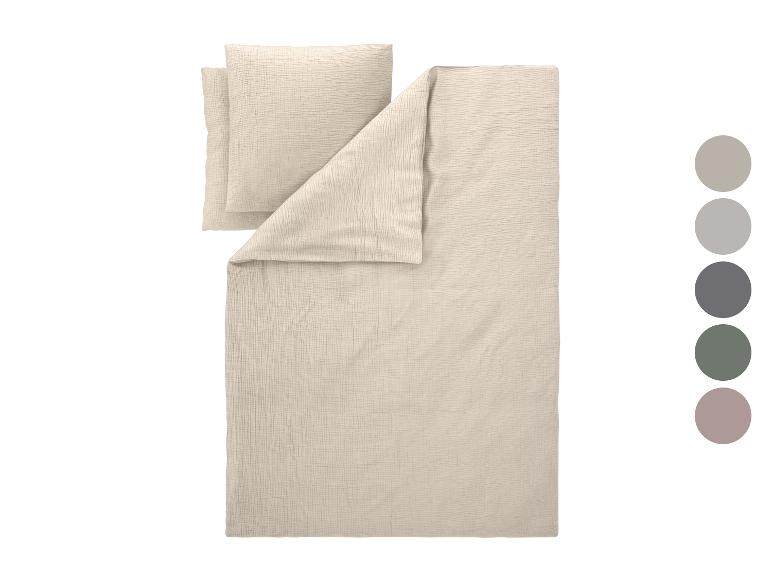 Parure de lit beige clair avec deux oreillers et une couette, avec une palette de couleurs.