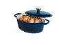 Cocotte en fonte bleue avec poulet rôti et légumes, couvercle partiellement ouvert.