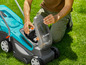 Un homme met une batterie dans une tondeuse robot Gardena.