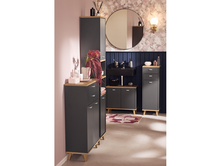Salle de bain avec meubles gris foncé et accents bois, mur rose et papier peint floral.