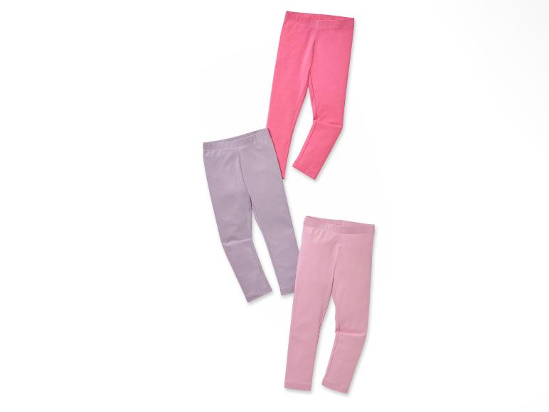 Deux leggings roses et un legging violet sur un fond blanc.