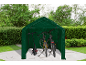 Abri à vélos vert avec un scooter électrique et deux vélos à l'intérieur, dans un jardin.