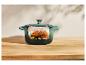 Un poulet rôti dans une cocotte en fonte vert bleuté.