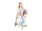 Fille souriante assise sur une chaise haute en bois et grise.