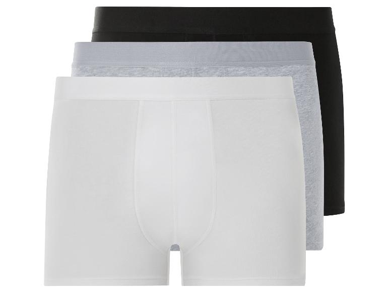 Trois paires de boxers en blanc, gris et noir.