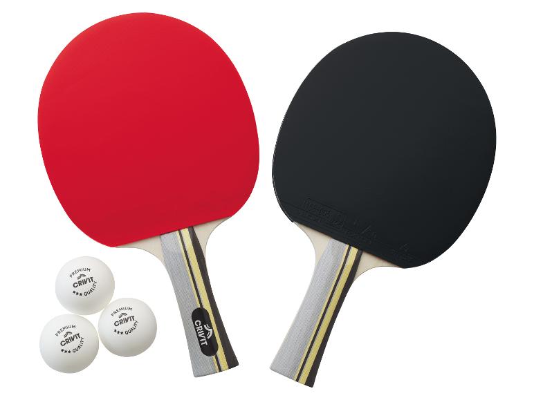 Deux raquettes de ping-pong Crivit, rouges et noires, avec trois balles.