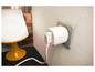 Une prise intelligente blanche branchée sur une prise de courant, à côté d'une lampe de table jaune.