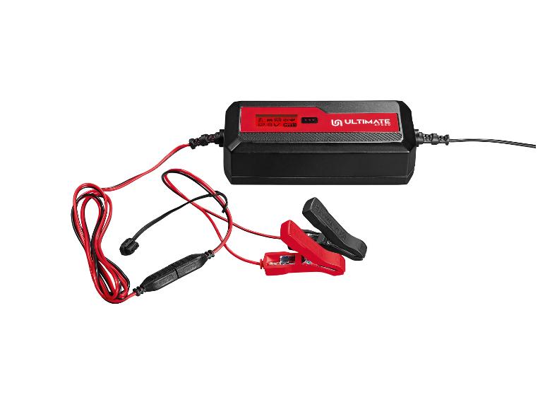 Un chargeur de batterie Ultimate Speed noir avec des pinces et des câbles rouges.