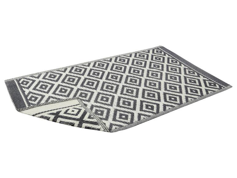 Tapis gris et blanc à motif géométrique, plié en deux